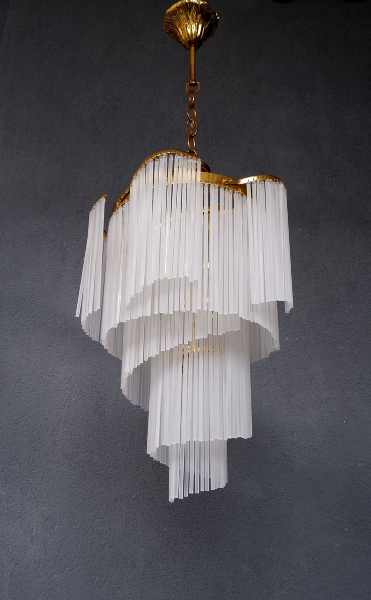 a chandelier hanging from the ceiling with white pleated fabric coverings on it