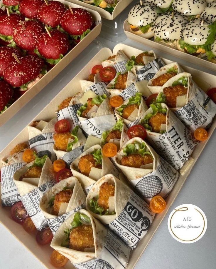 several trays filled with different types of wraps and strawberries next to each other