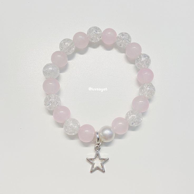 a pink bracelet with a silver star charm and white glass beaded beads on it