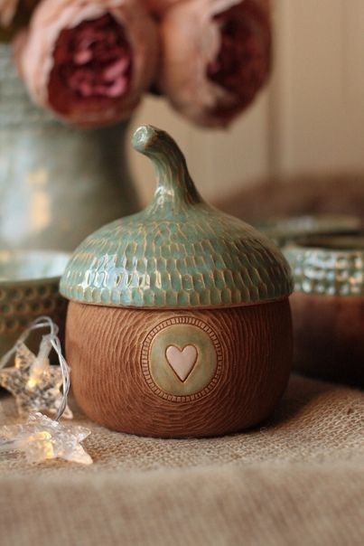 two vases with roses in the background and one has a heart decoration on it