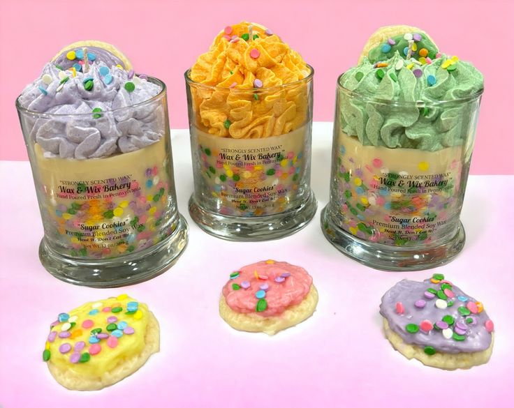 four decorated cookies in glass containers on a table