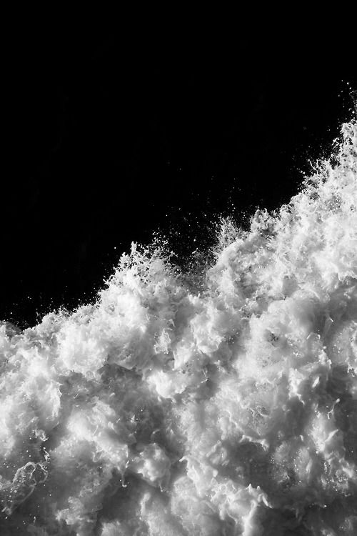 black and white photograph of the top of a snowboarder's board in mid air