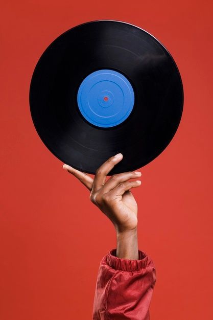 a person holding up a black record in the air