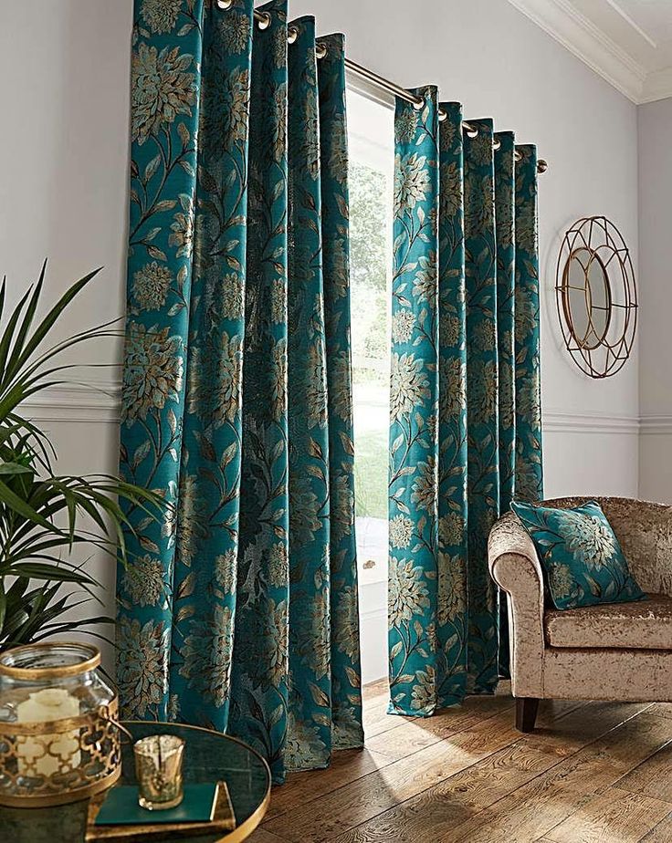 a living room filled with furniture and a window covered in blue drapes next to a wooden floor