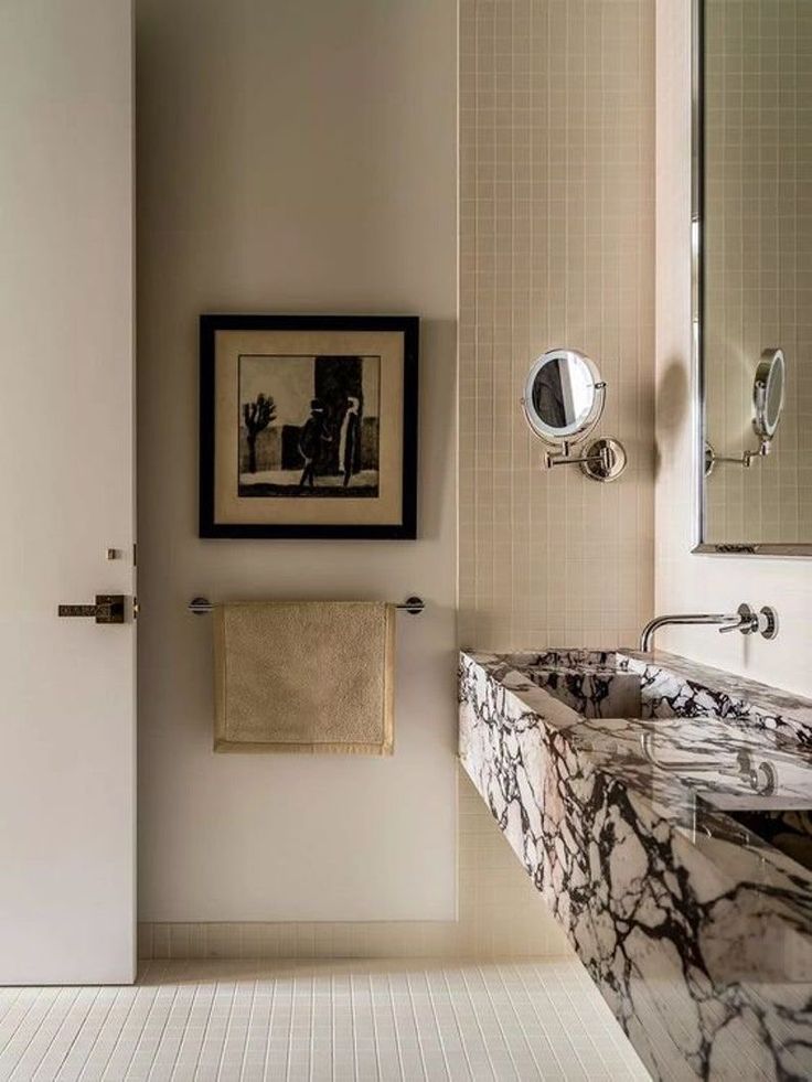 a bathroom with marble counter tops and white walls