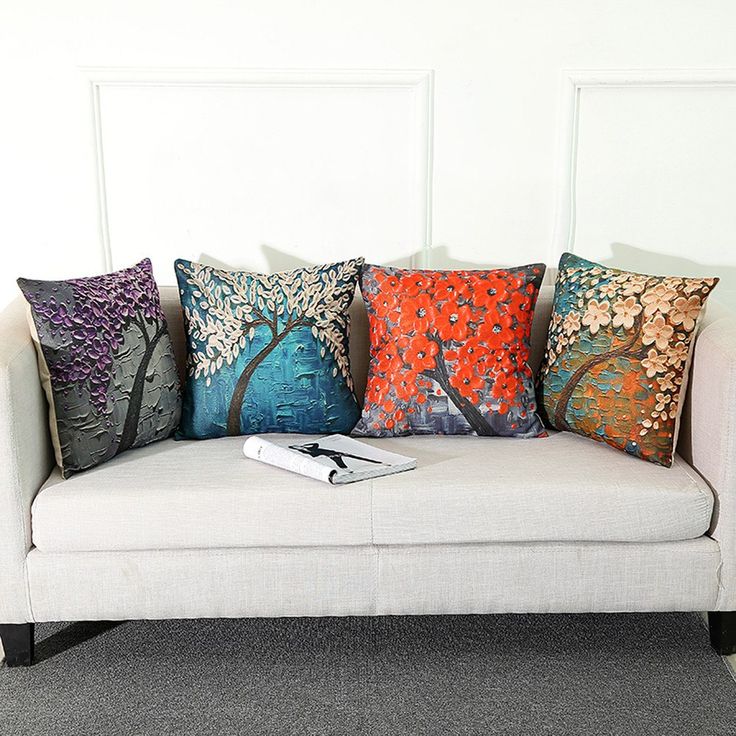 a white couch with four colorful pillows on it