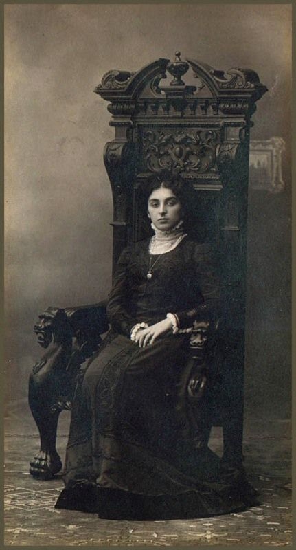 an old photo of a woman sitting on a chair