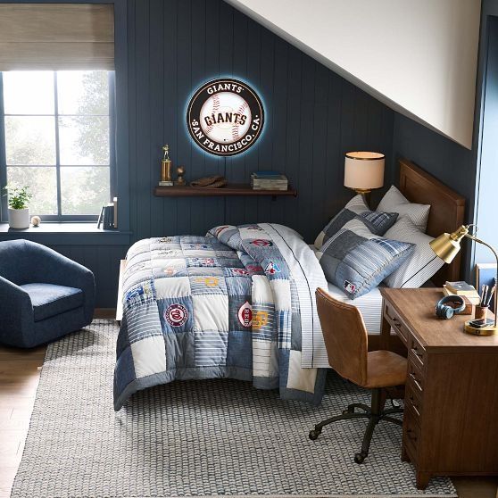 a bed room with a neatly made bed next to a chair and desk in front of a window