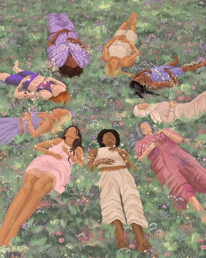 several women laying in the grass with their arms around each other