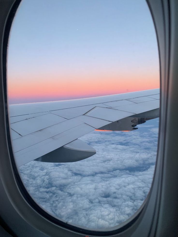 an airplane window looking out at the clouds