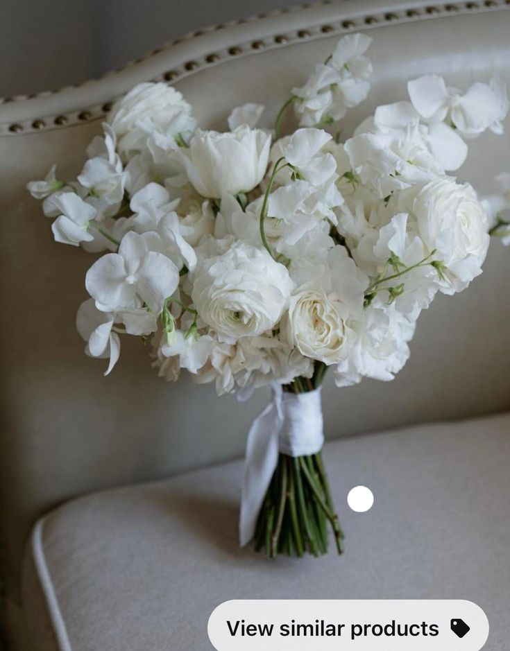 a bouquet of white flowers sitting on top of a chair