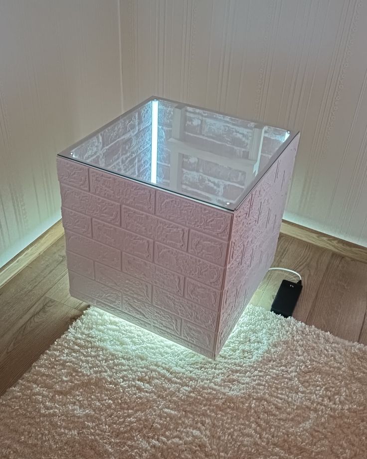 a pink box sitting on top of a carpeted floor next to a white wall