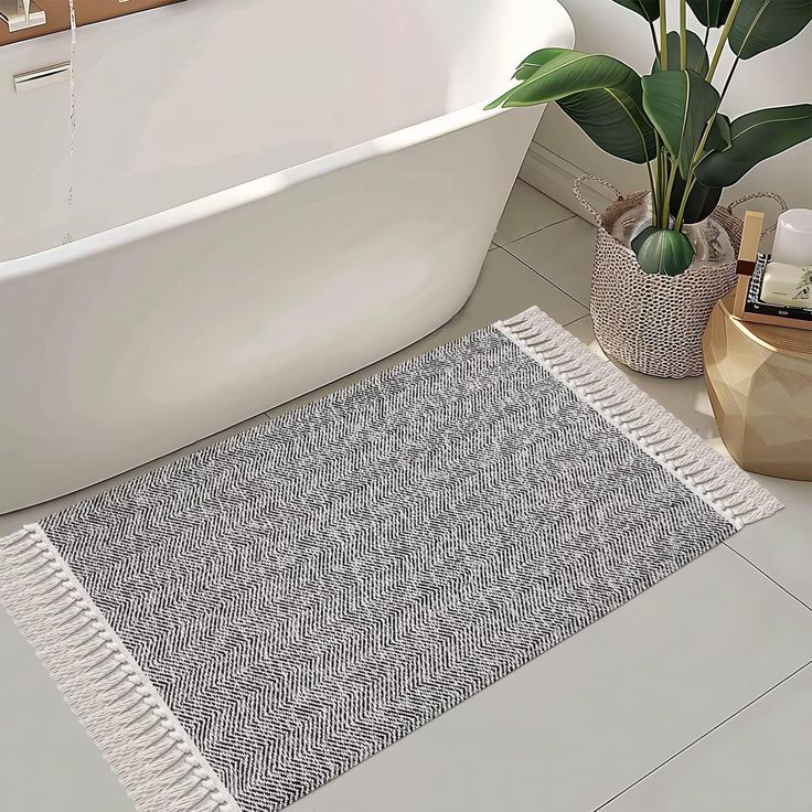 a bath tub sitting next to a potted plant on top of a white floor