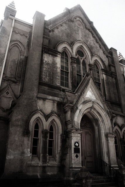 an old church building with many windows and stairs leading up to the front door is shown in black and white