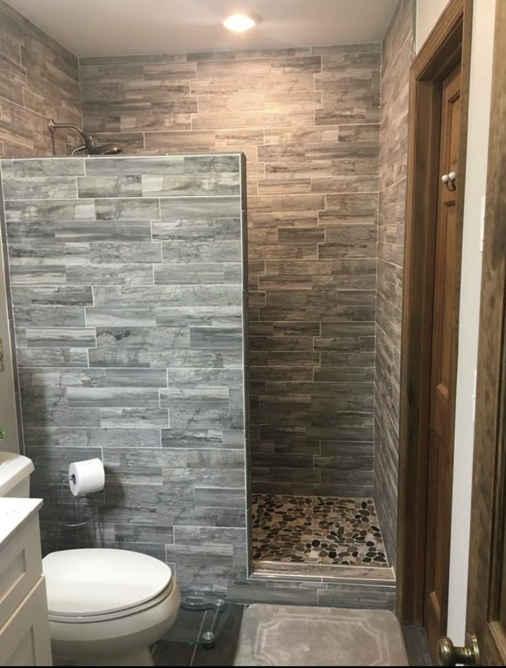 a bathroom with a walk in shower next to a toilet