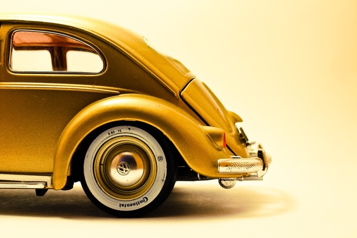 an old model car is shown on a white surface with yellow and orange colors in the background