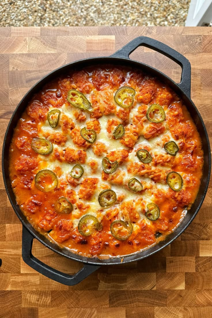 a pizza in a pan sitting on top of a wooden cutting board