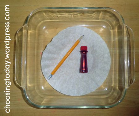 a glass container with a pencil and paper on it