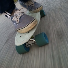 a person riding a skateboard down a street with one foot on the board and two feet on the ground