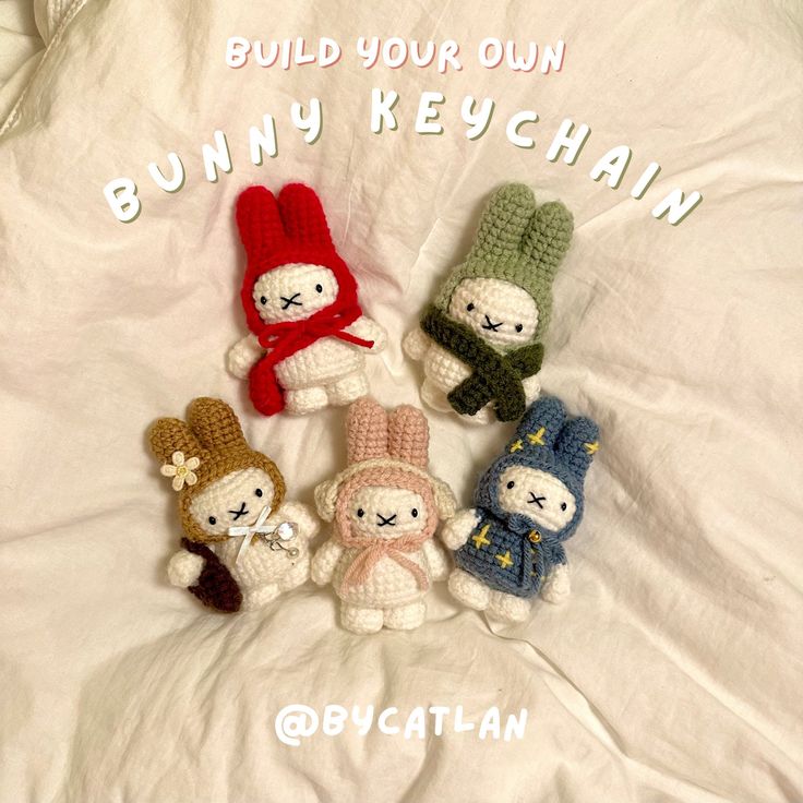 four crocheted bunny keychains sitting on top of a white sheet with the words build your own bunny keychain