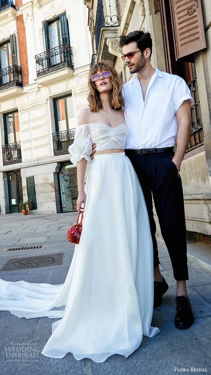 a man and woman standing next to each other in front of a building with windows