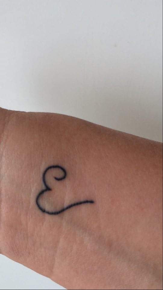 a person's arm with a small tattoo on the left side of their arm