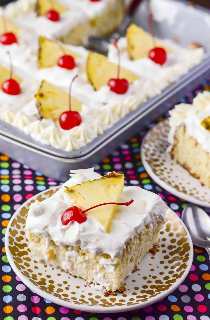 two pieces of pineapple poke cake with white frosting and cherries