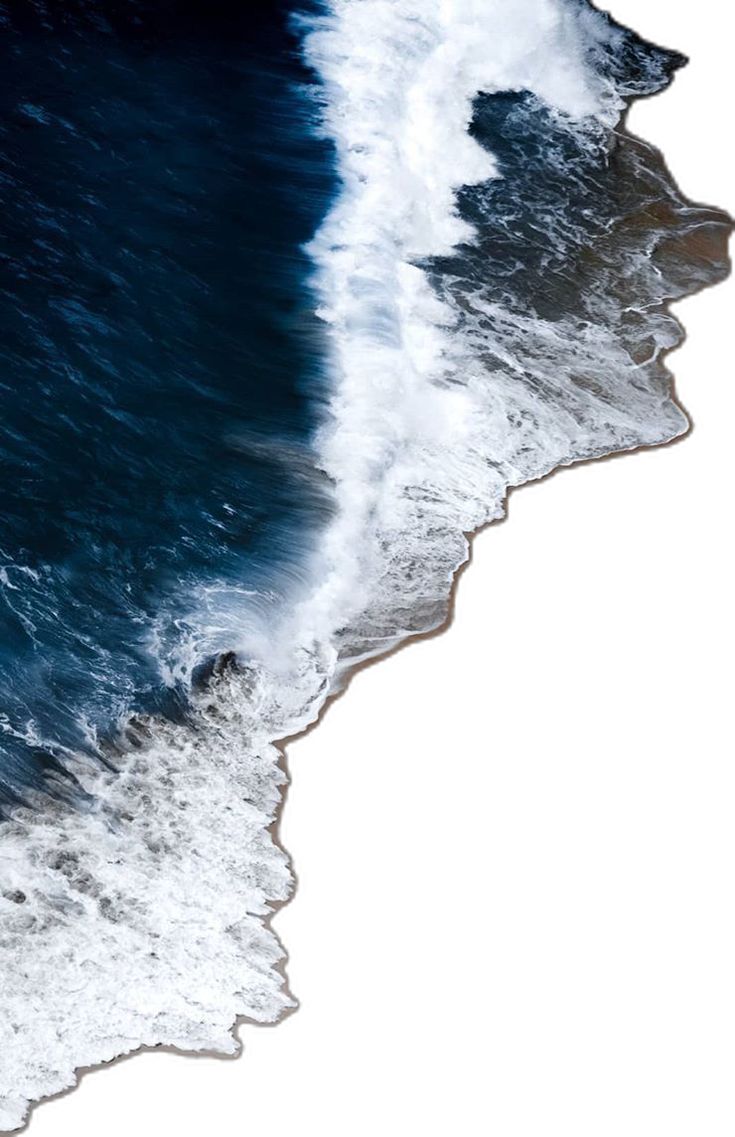 an aerial view of the ocean with waves coming in