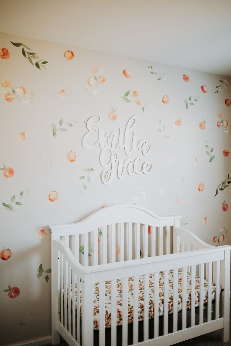 a white crib in front of a floral wall