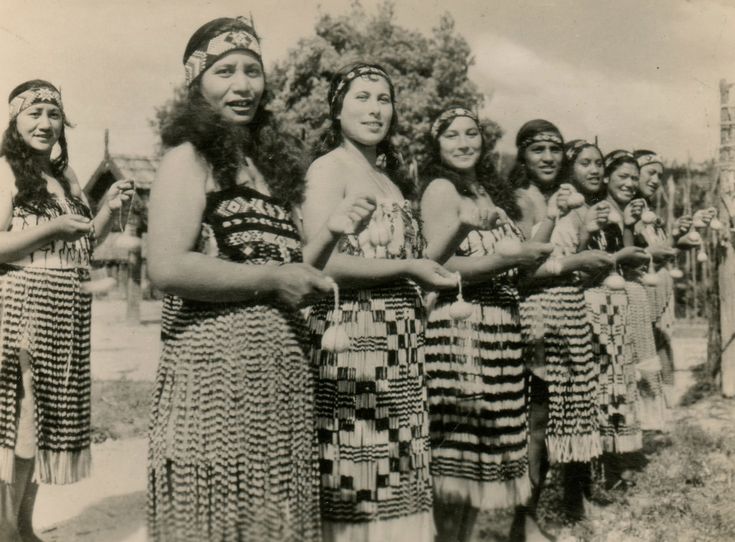 an old black and white photo of native american women standing in front of each other