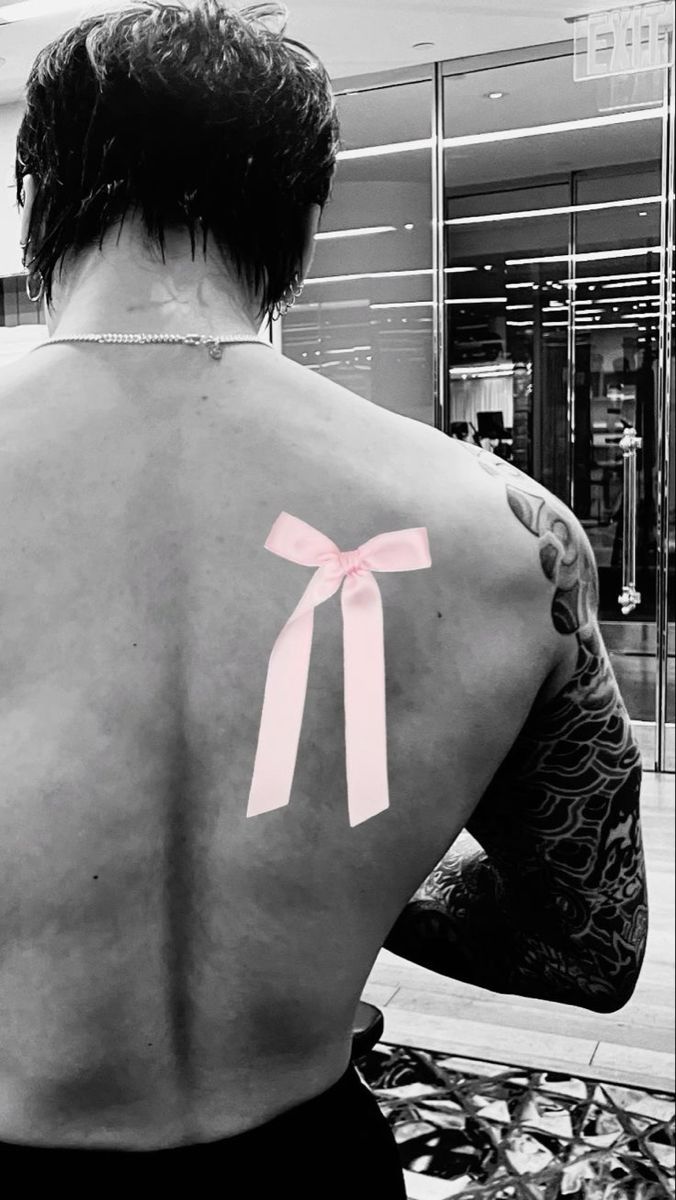 a man with a pink bow on his back