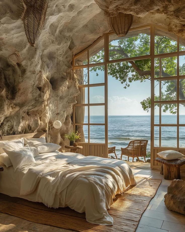 a bedroom with large windows overlooking the ocean