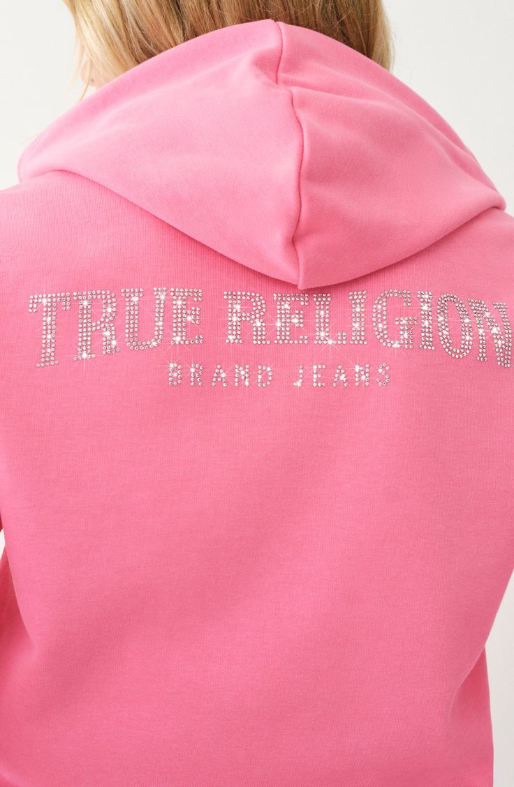 A logo of shimmering rhinestones spans ths back of this zip-up hoodie to bring a touch of glam to your everyday look. 23" length Front zip closure Drawstring hood Split kangaroo pocket 60% cotton, 40% polyester Machine wash, line dry Imported True Religion Set, Baddie Hoodies, Hot Pink Outfits, Cute Zip Up Hoodie, Pink Hoodie Outfit, Usa Clothes, True Religion Hoodie, Hot Pink Outfit, Light Pink Hoodie