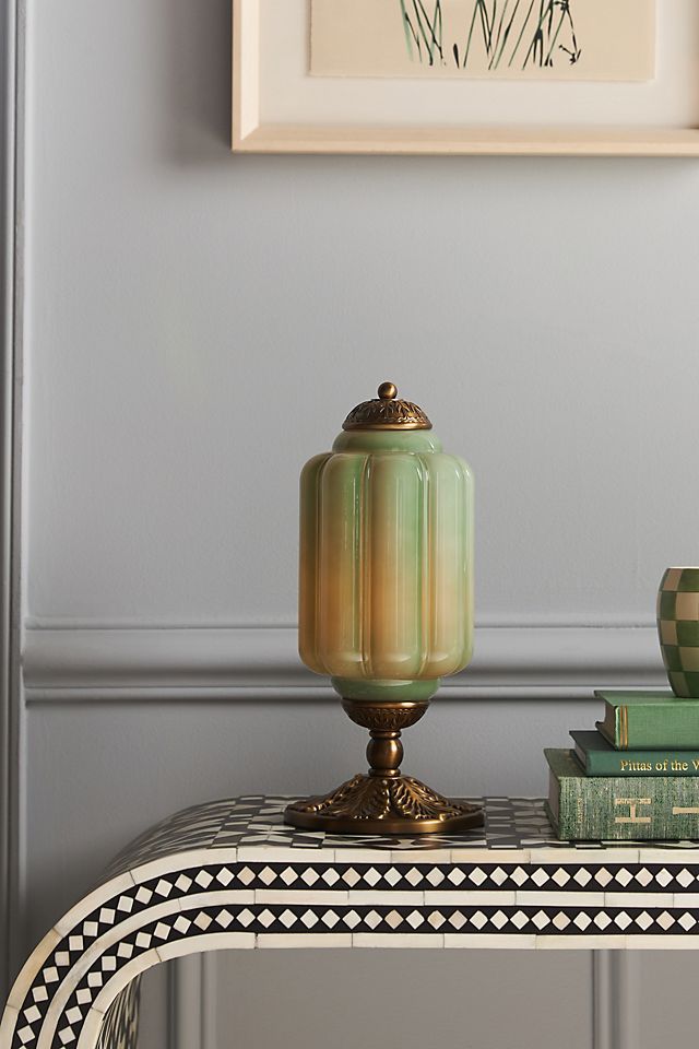 a table with some books on it and a vase sitting on top of the table