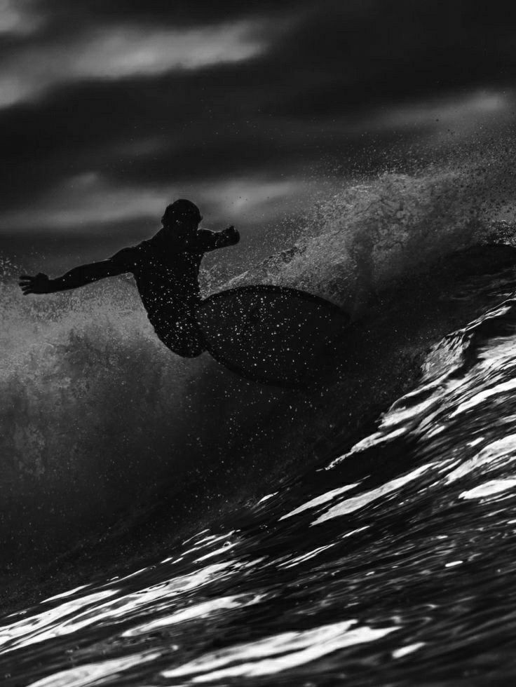 a man riding a wave on top of a surfboard in the middle of the ocean