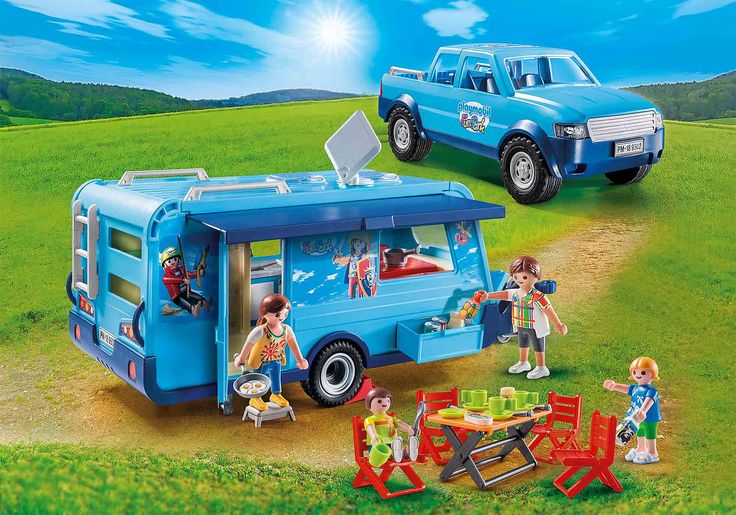 two playmobils are in the grass near a camper and picnic table