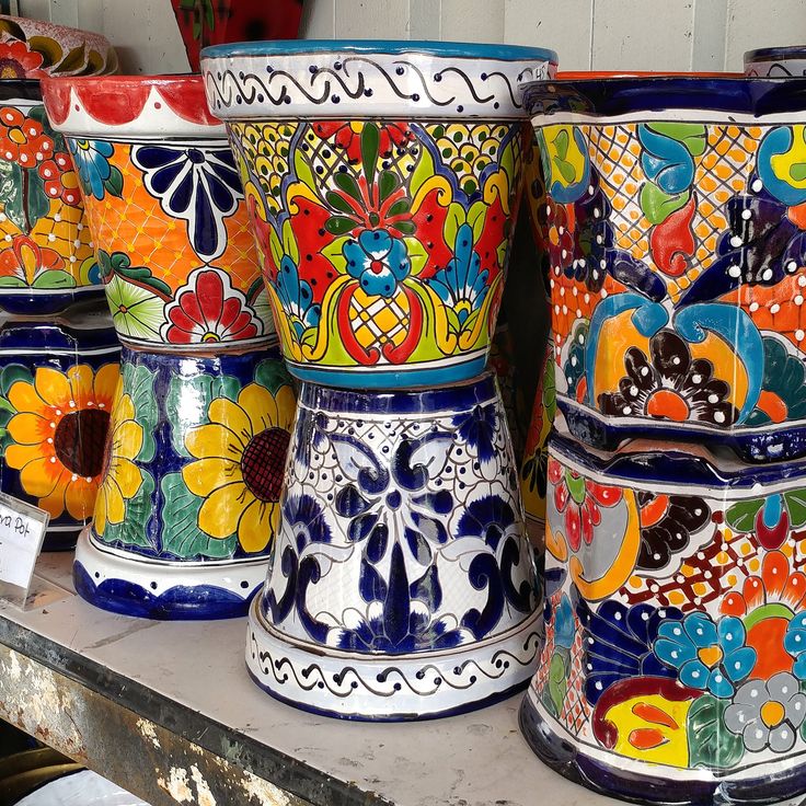 many colorful vases are sitting on a shelf