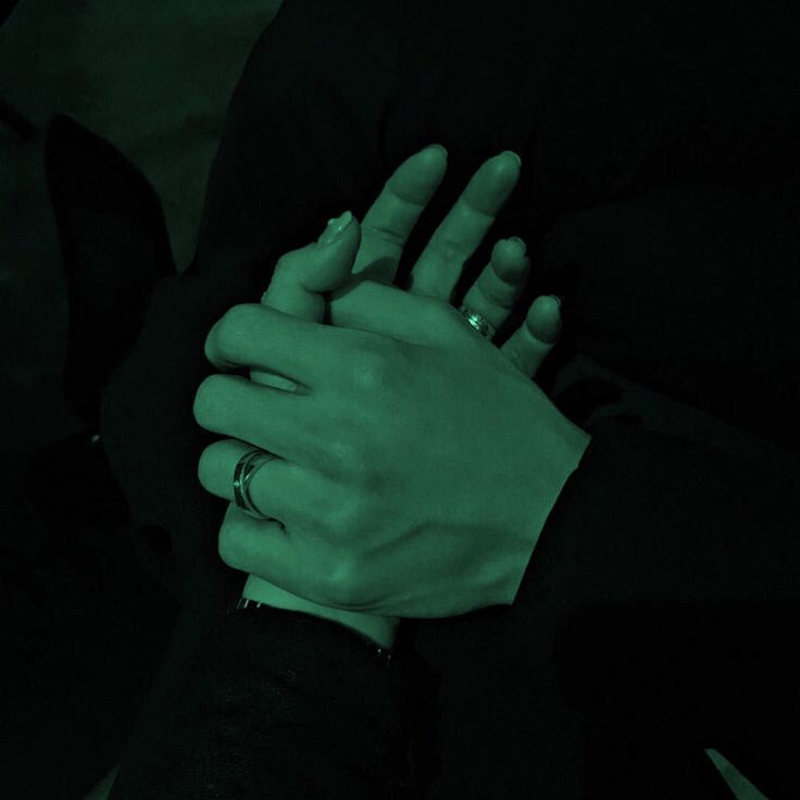 two hands holding each other in the dark