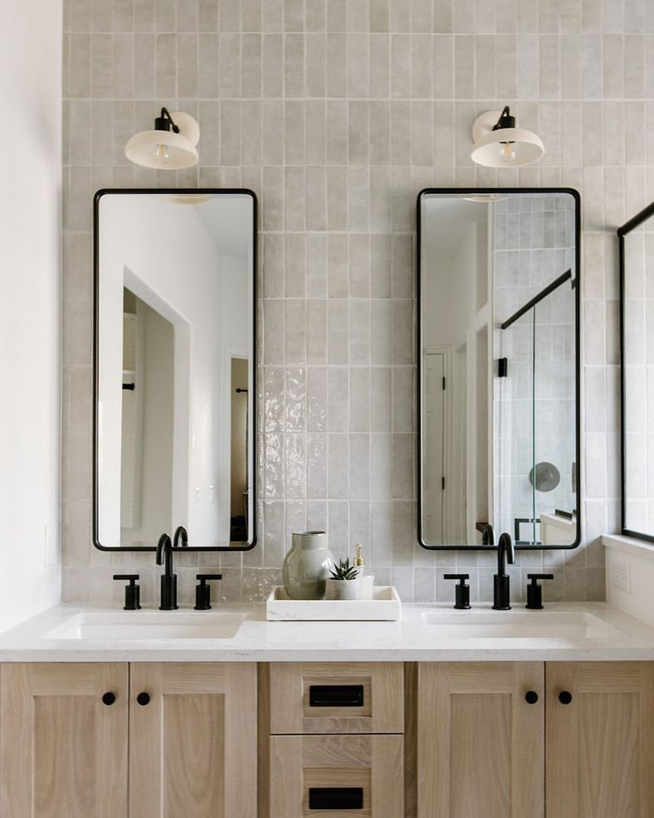 a bathroom with two sinks and mirrors on the wall