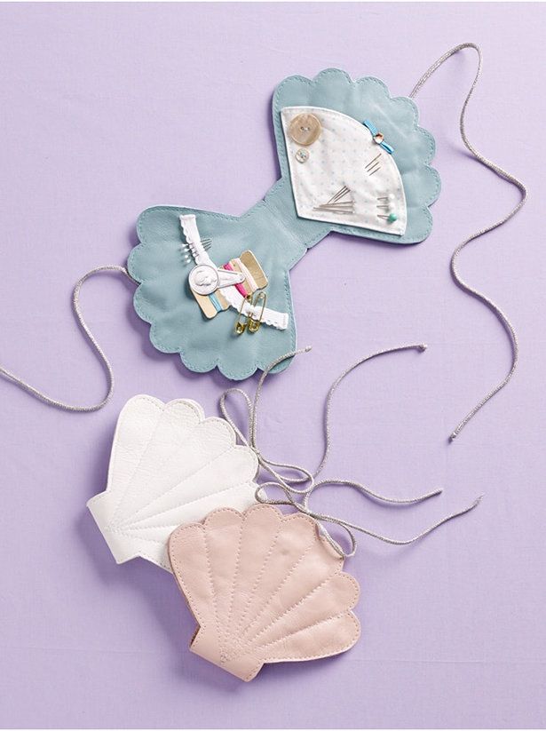 three pieces of clothing hanging from strings on a purple wall with white and blue accents