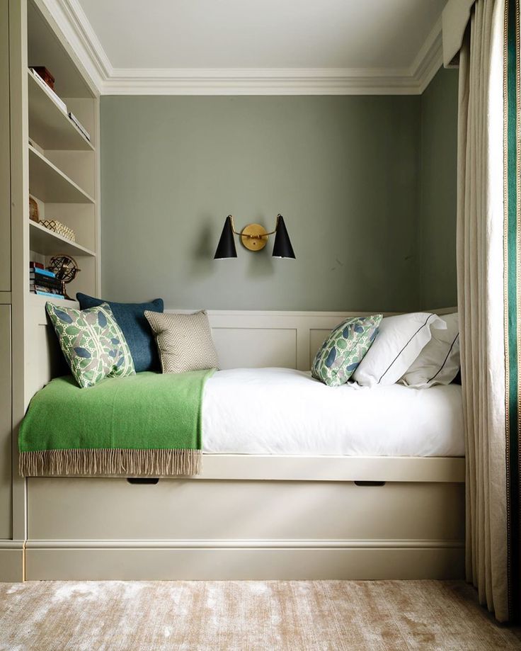 a bedroom with green and white decor on the walls, carpeted flooring and built in bookshelves