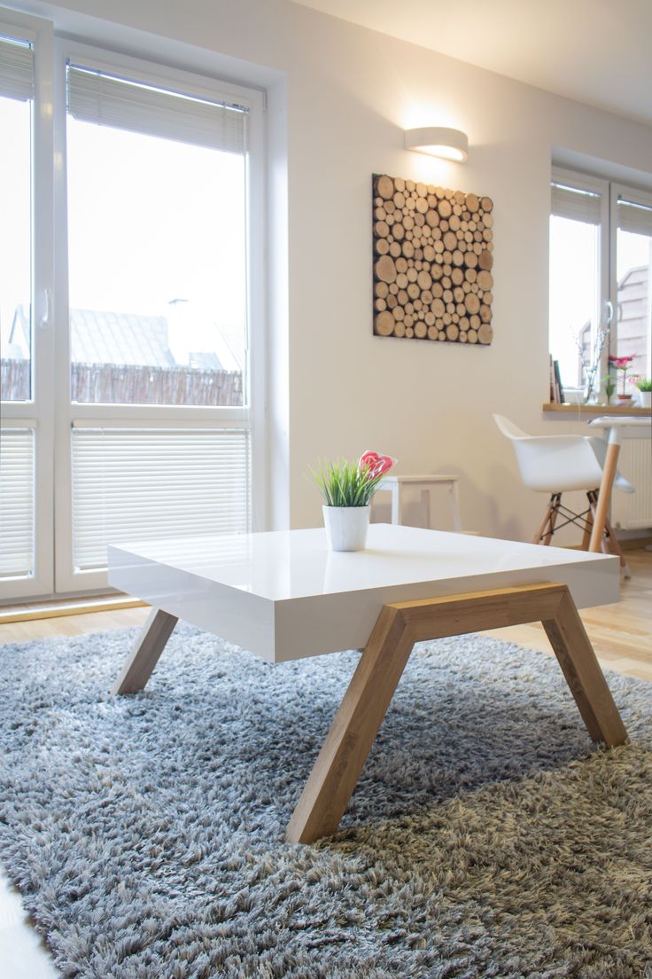 a white coffee table sitting on top of a rug in a living room next to a window