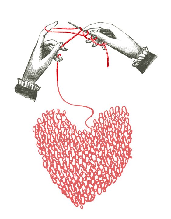 two hands holding yarn over a heart shaped object