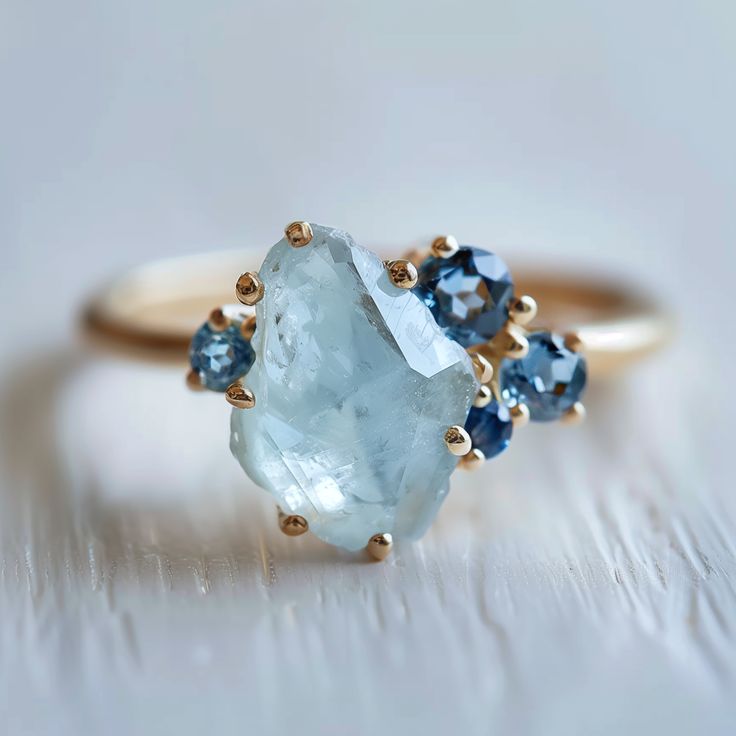 an aqua and blue topaz ring on a white surface