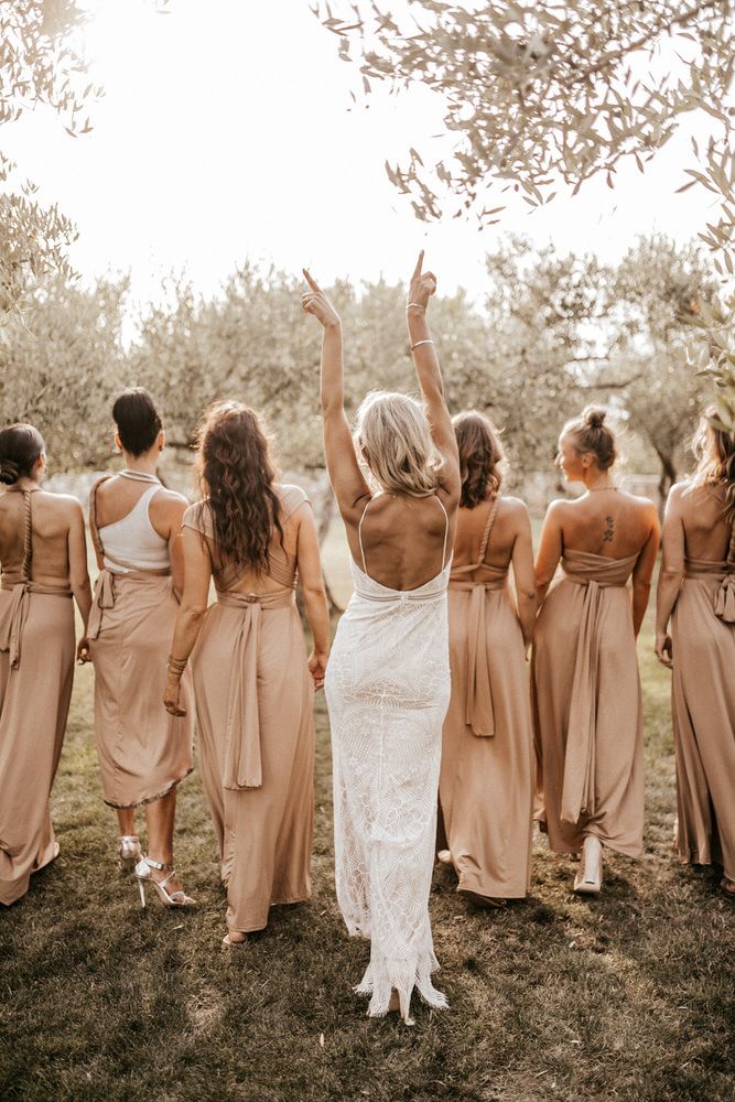 the bridesmaids are throwing their bouquets in the air as they walk through an olive grove