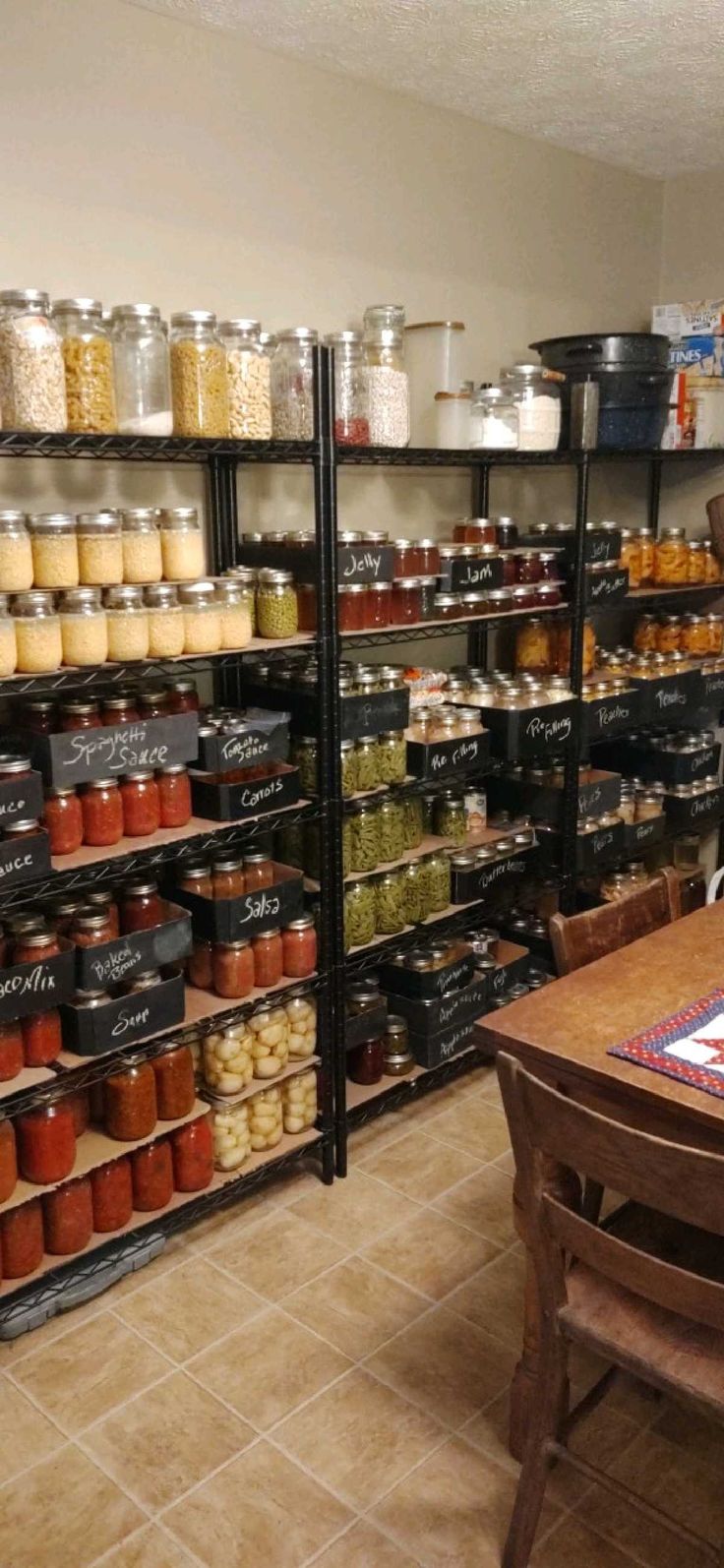 a room filled with lots of different types of jars and containers on the wall next to a wooden table