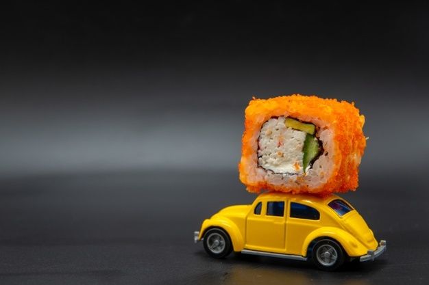 a yellow toy car with sushi on top