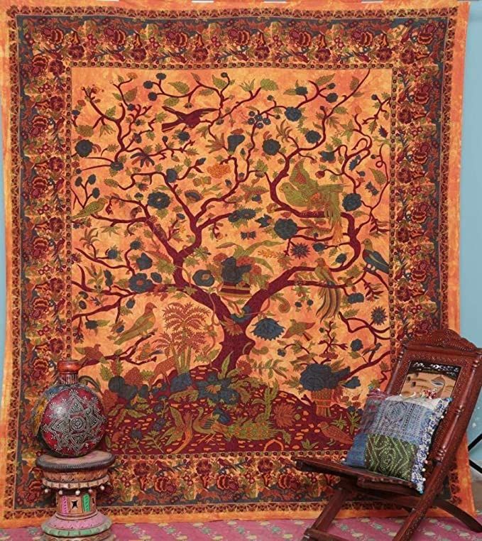 the tree of life tapestry is on display next to a wooden chair and table with a vase