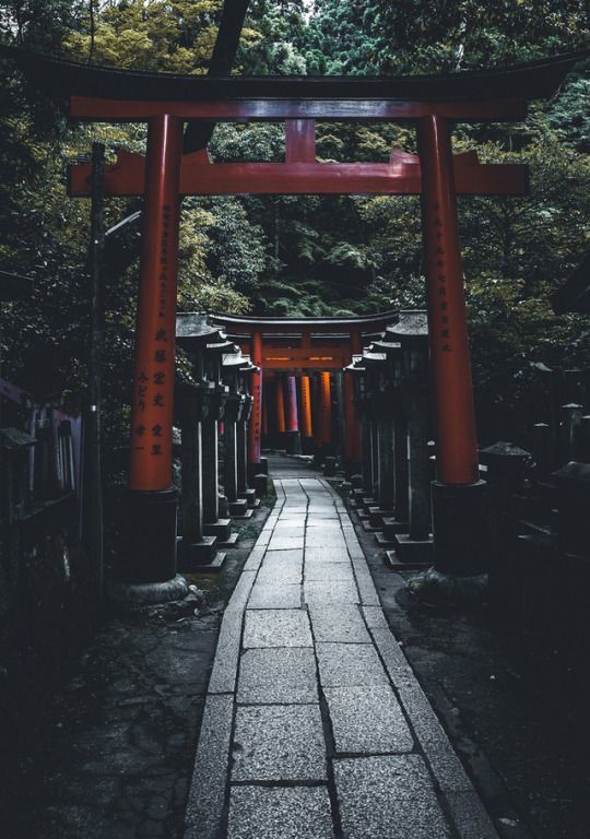 a walkway leading to a shrine in the woods