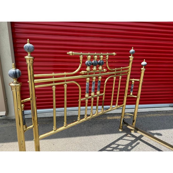 a gold metal bed frame with four posts